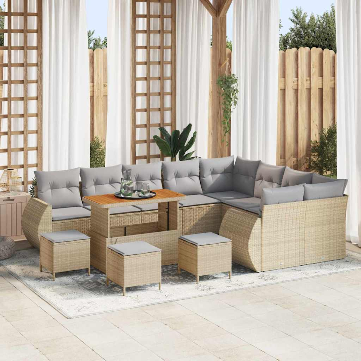 Außenbereich mit Korbmöbeln, grauen Kissen, Holztisch und Vorhängen. Enthält ein Sofa, Hocker und einen Teppich.