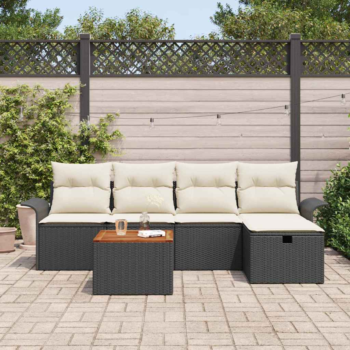 Gartensofa mit beigen Kissen und einem Holztisch. Die Szene spielt in einem Garten mit Zaun und Pflanzen.