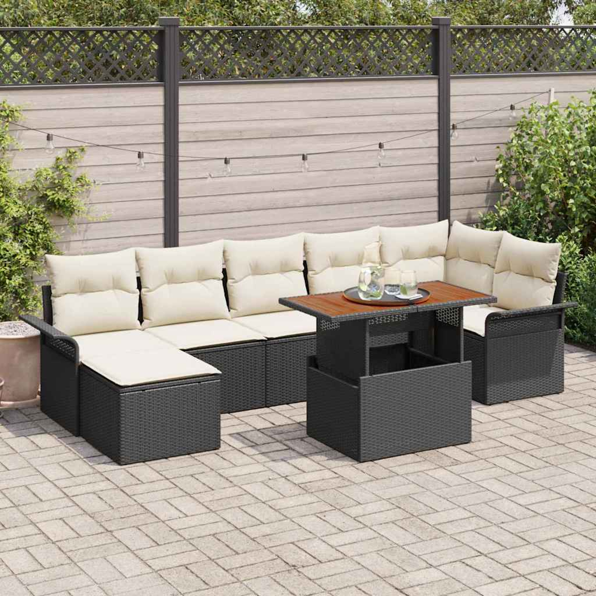 Garten-Sitzgruppe mit beigefarbenen Kissen. Ein Tisch mit Holzplatte steht davor. Die Szene spielt auf einer Terrasse, im Hintergrund ein Zaun.