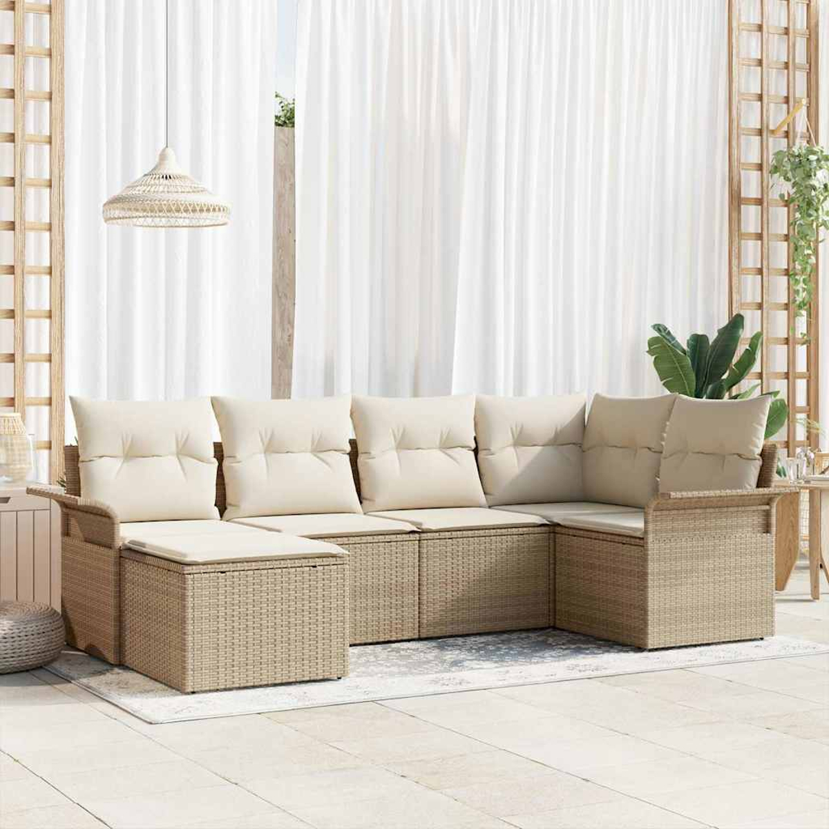 Un sof á seccional de mimbre beige con cojines crema en un patio. Cortinas blancas y una lámpara colgante al fondo.