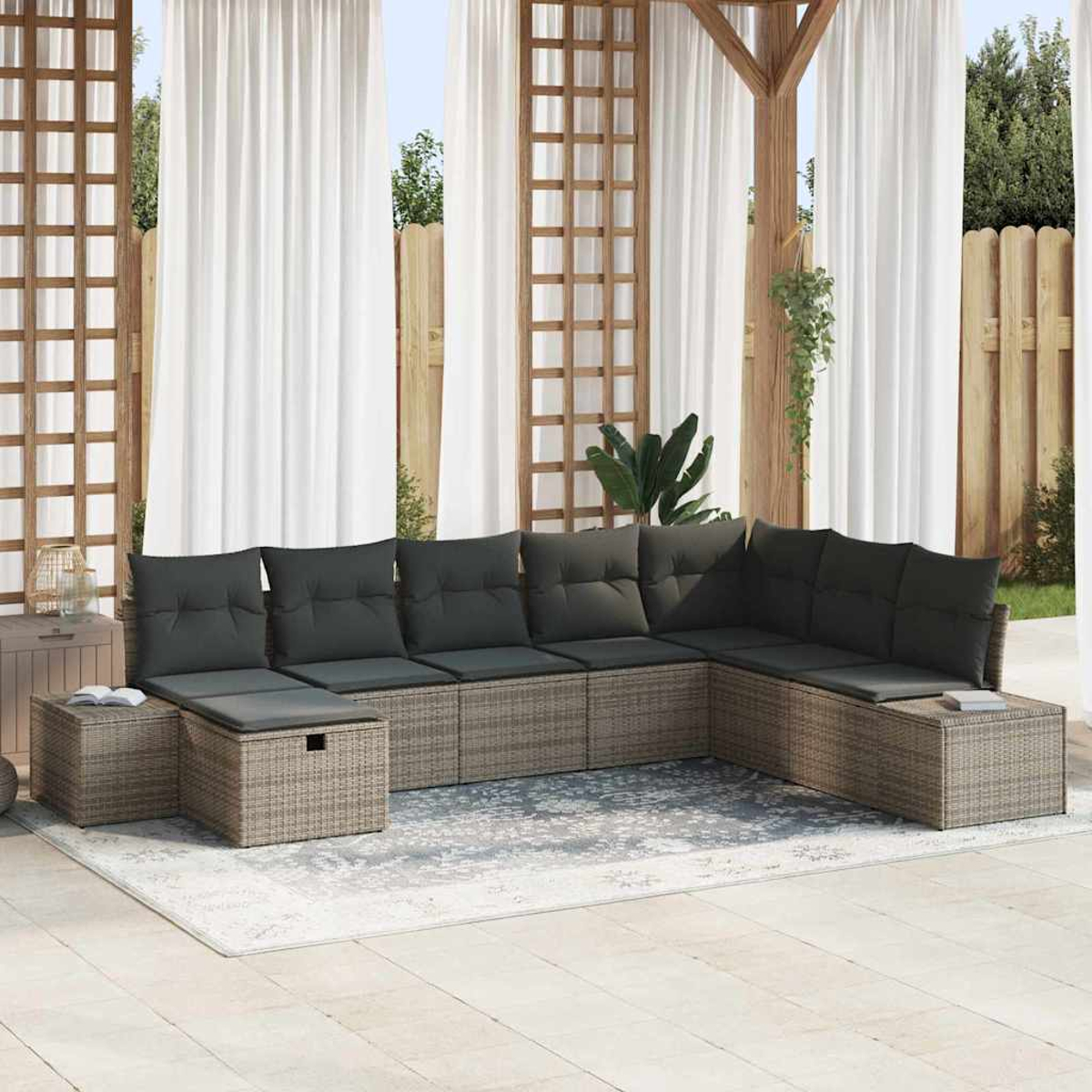 Outdoor-Ecksofa mit grauen Kissen auf einem Teppich. Weiße Vorhänge, Holzpergola und Holzzaun im Hintergrund.