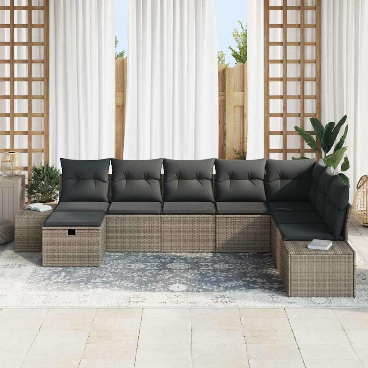 Outdoor-Ecksofa mit grauen Kissen auf einem gemusterten Teppich. Weiße Vorhänge und Holzgitter im Hintergrund.