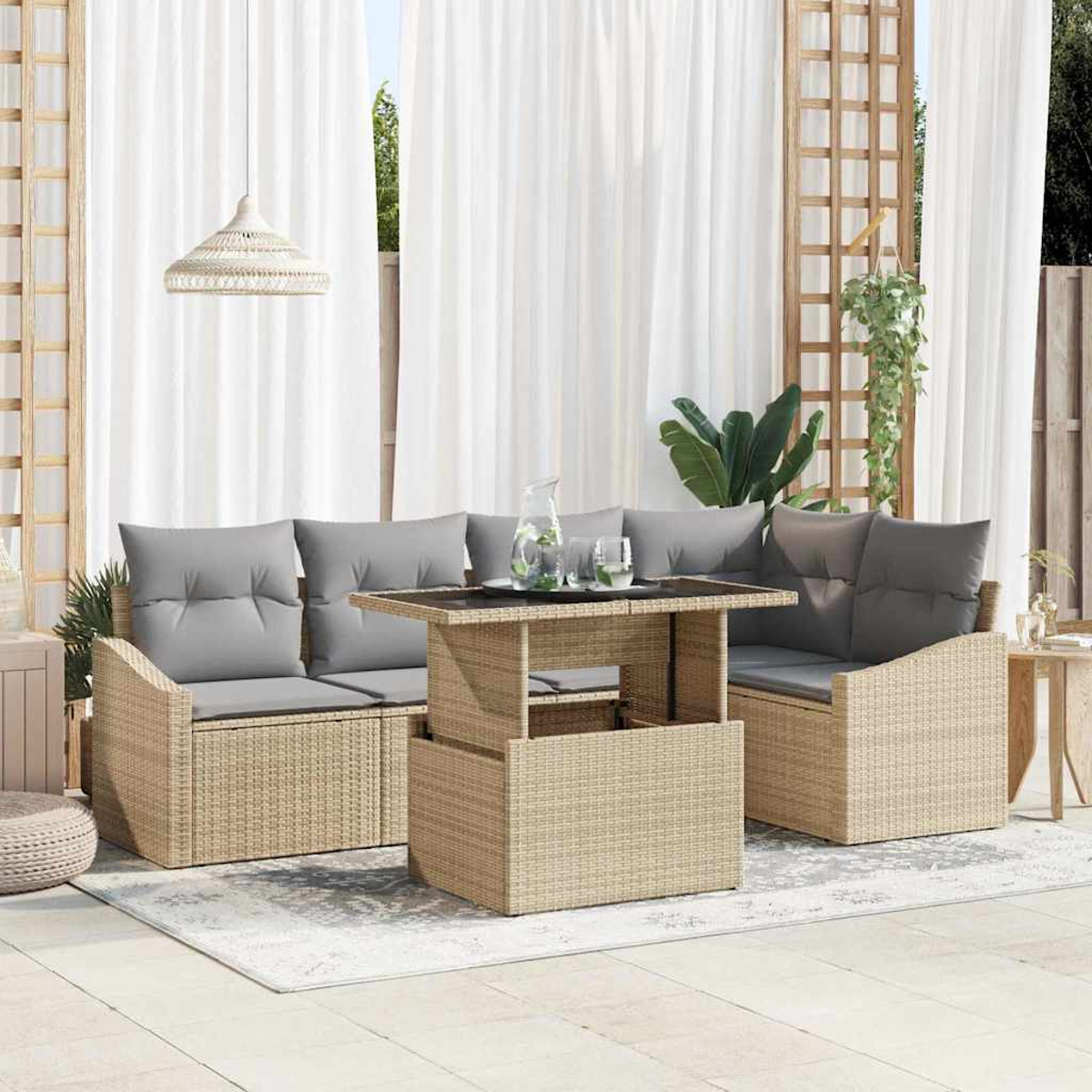 Ein Sitzbereich im Freien mit einem Korbmöbel-Sofa, Tisch und Sessel. Graue Kissen, weiße Vorhänge und eine Pflanze.