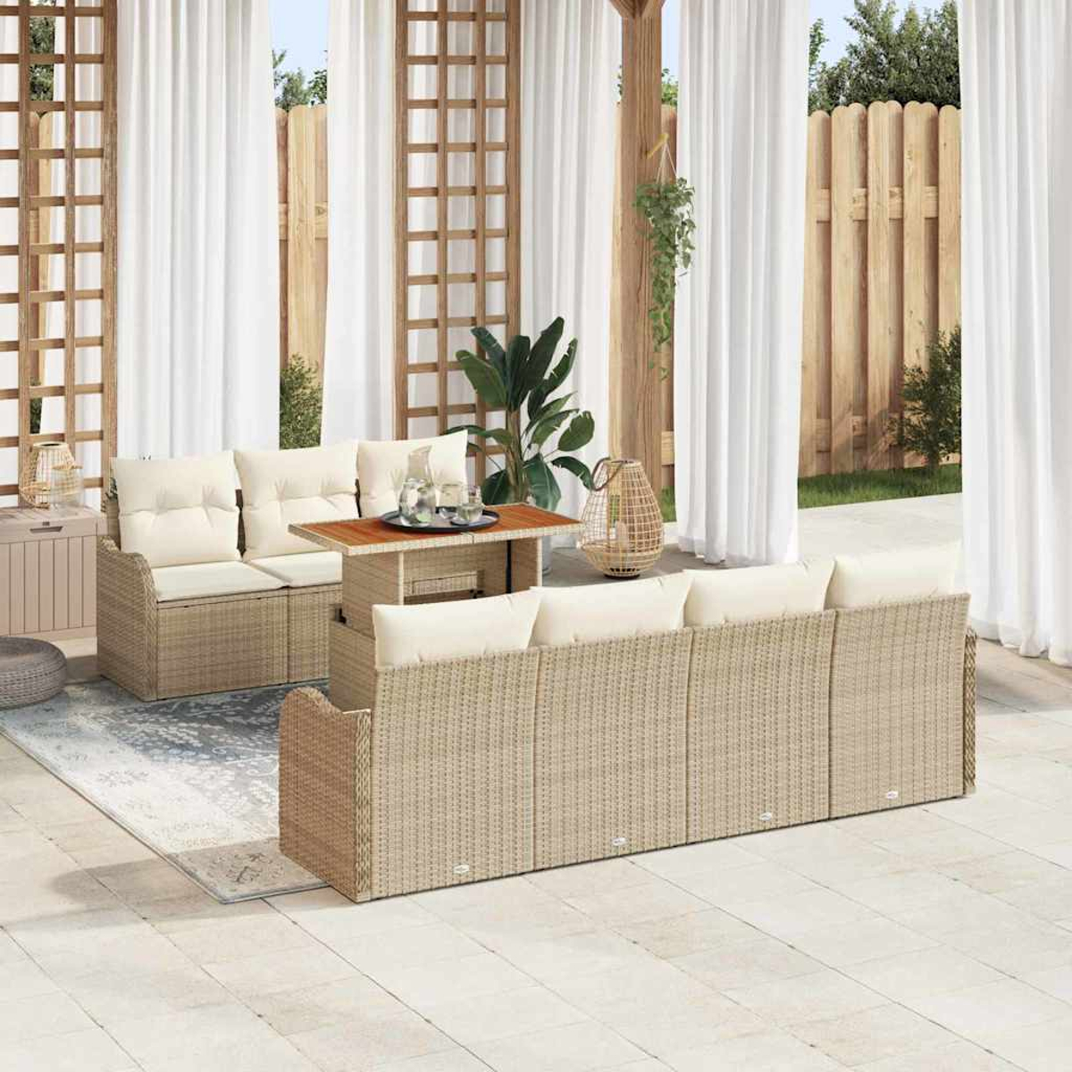 Terrassenset mit cremefarbenen Kissen. Enthält Sofa, Tisch und Stühle. Weiße Vorhänge, Holzzaun und Grünzeug vervollständigen die Szene.
