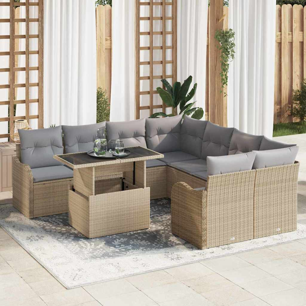 Sofá seccional exterior con cojines grises y mesa elevable sobre alfombra estampada. Fondo con cortinas y enrejado de madera.