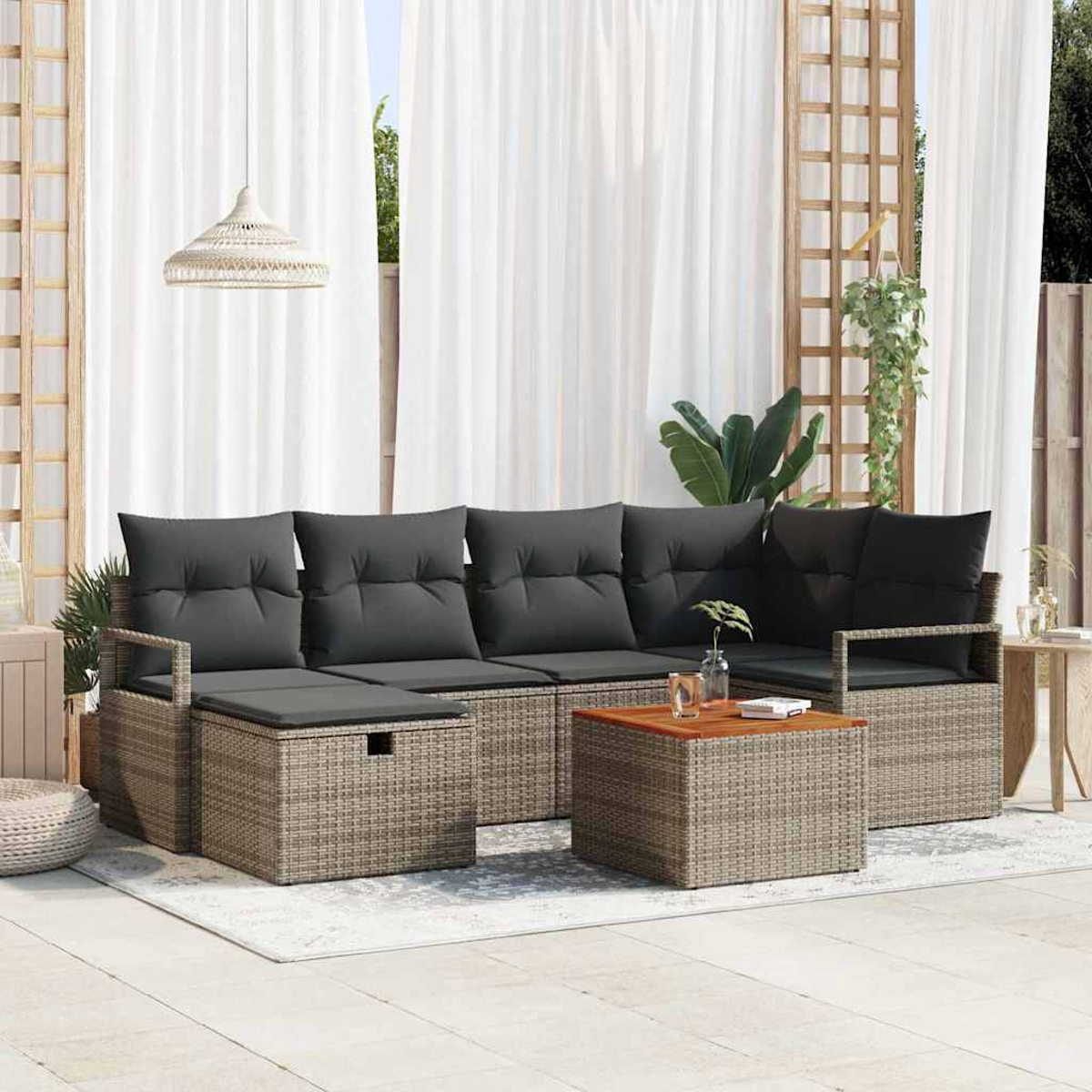 Garten-Terrassenset mit grauen Kissen. Enthält ein Sofa, einen Ottomanen und einen Couchtisch auf einer Terrasse mit weißen Vorhängen.