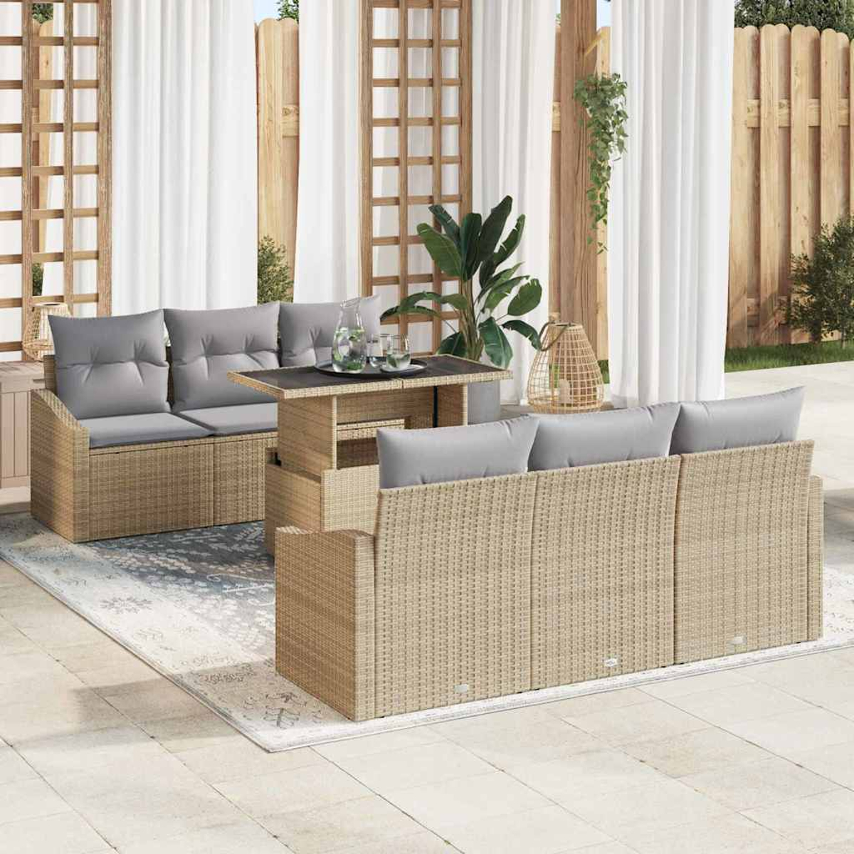 Gartenmöbel-Set mit Korbs Sofas, grauen Kissen und einem Tisch. Pflanzen und Vorhänge im Hintergrund, auf einer Terrasse.