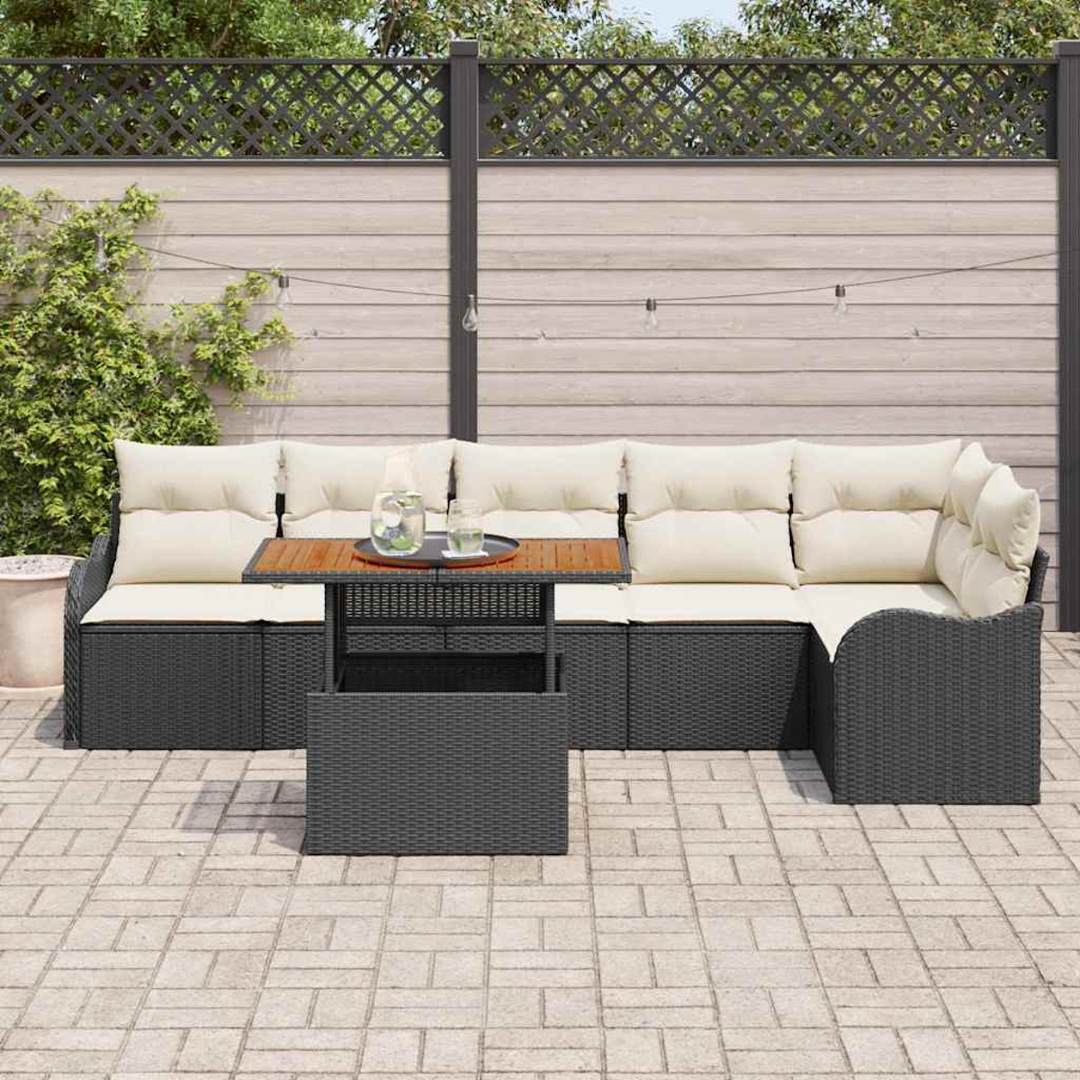 Gartencouch mit cremefarbenen Kissen und einem Holztisch. Im Hintergrund ein Zaun, Grün und eine Backsteinterrasse.