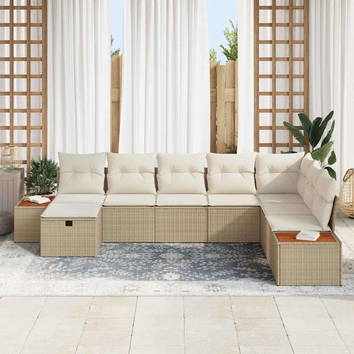 Ein Ecksofa mit cremefarbenen Kissen steht auf einem Teppich. Weiße Vorhänge und Holzgitter umgeben es. Pflanzen und ein Beistelltisch sind sichtbar.
