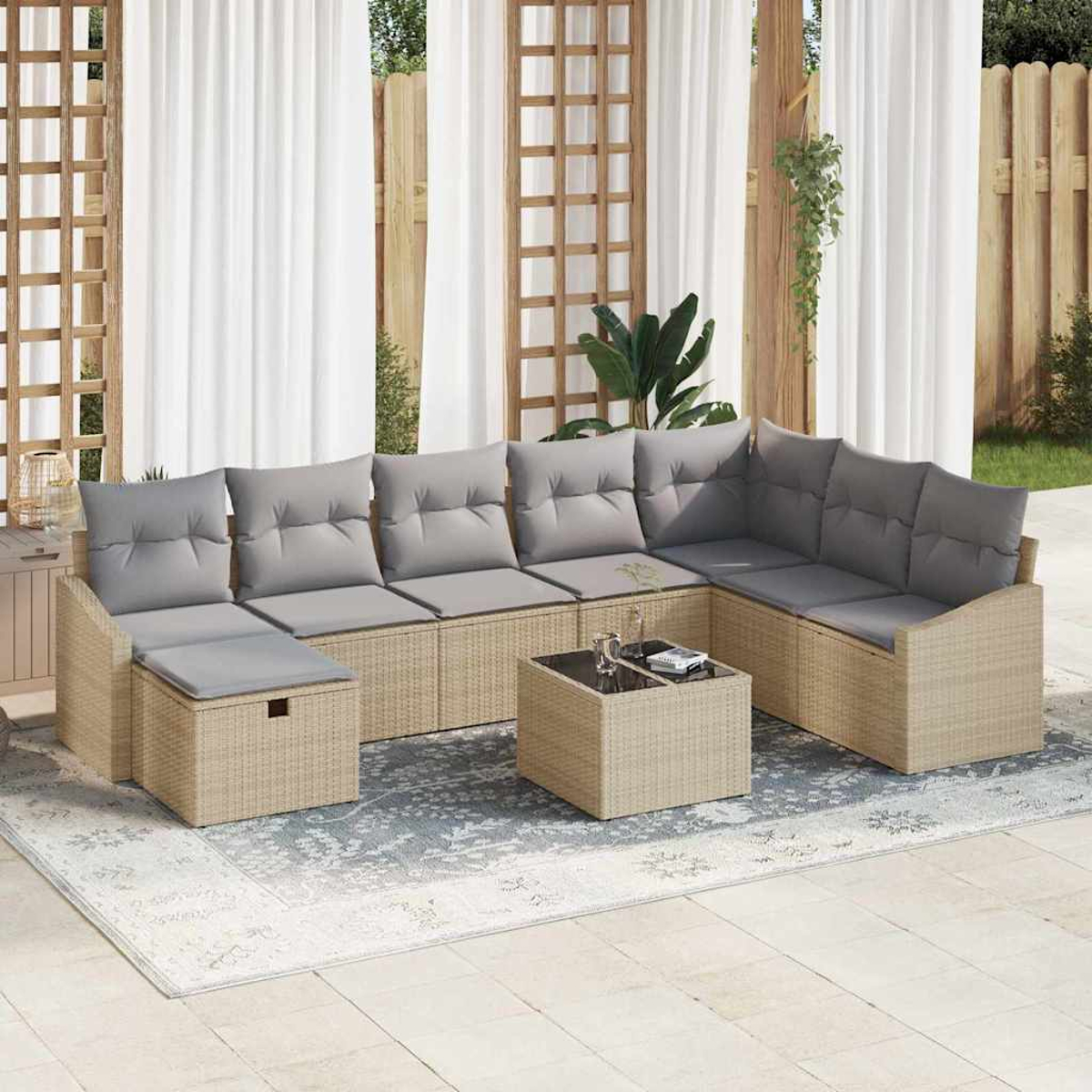 Gartensofa mit grauen Kissen und einem quadratischen Couchtisch auf einem gemusterten Teppich. Weiße Vorhänge und Holzgitter im Hintergrund.
