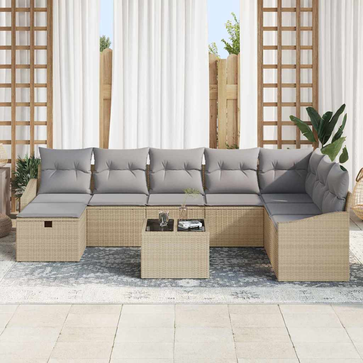Outdoor-Ecksofa mit grauen Kissen, Couchtisch und Teppich auf einer Terrasse. Hintergrund hat weiße Vorhänge und Holzzaun.