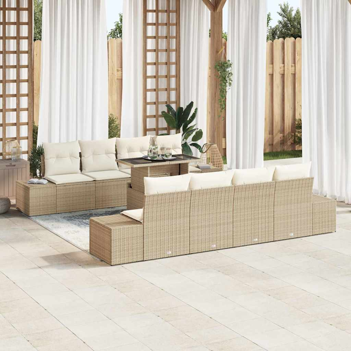 Gartenmöbel-Set aus Korbgeflecht. Beinhaltet Sofa, Tisch und Bänke. Weiße Vorhänge und Holzzaun im Hintergrund.