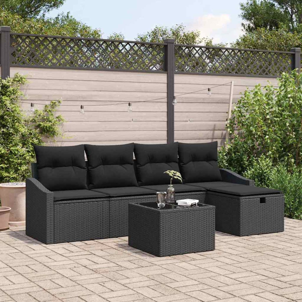 Outdoor-Terrassenset mit schwarzen Kissen. Enthält ein Sofa, einen Tisch und eine Aufbewahrungshocker auf einer Ziegelterrasse, umgeben von Grün.