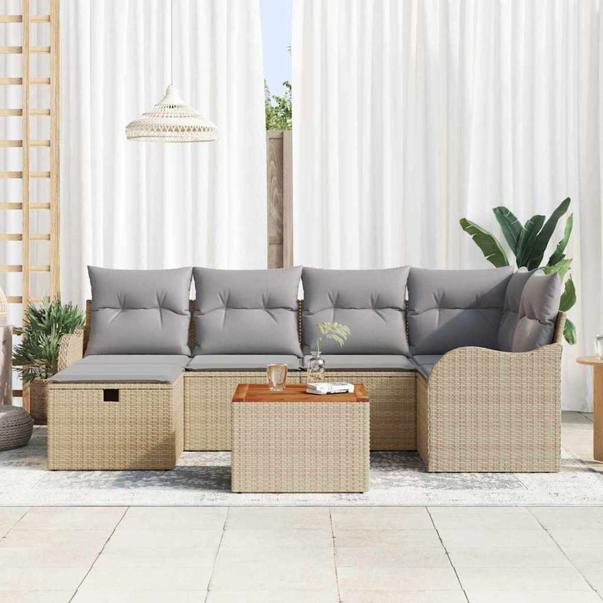 Outdoor-Wicker-Sofa mit grauen Kissen, einem passenden Tisch und einer Hängeleuchte. Weiße Vorhänge und Pflanzen im Hintergrund.