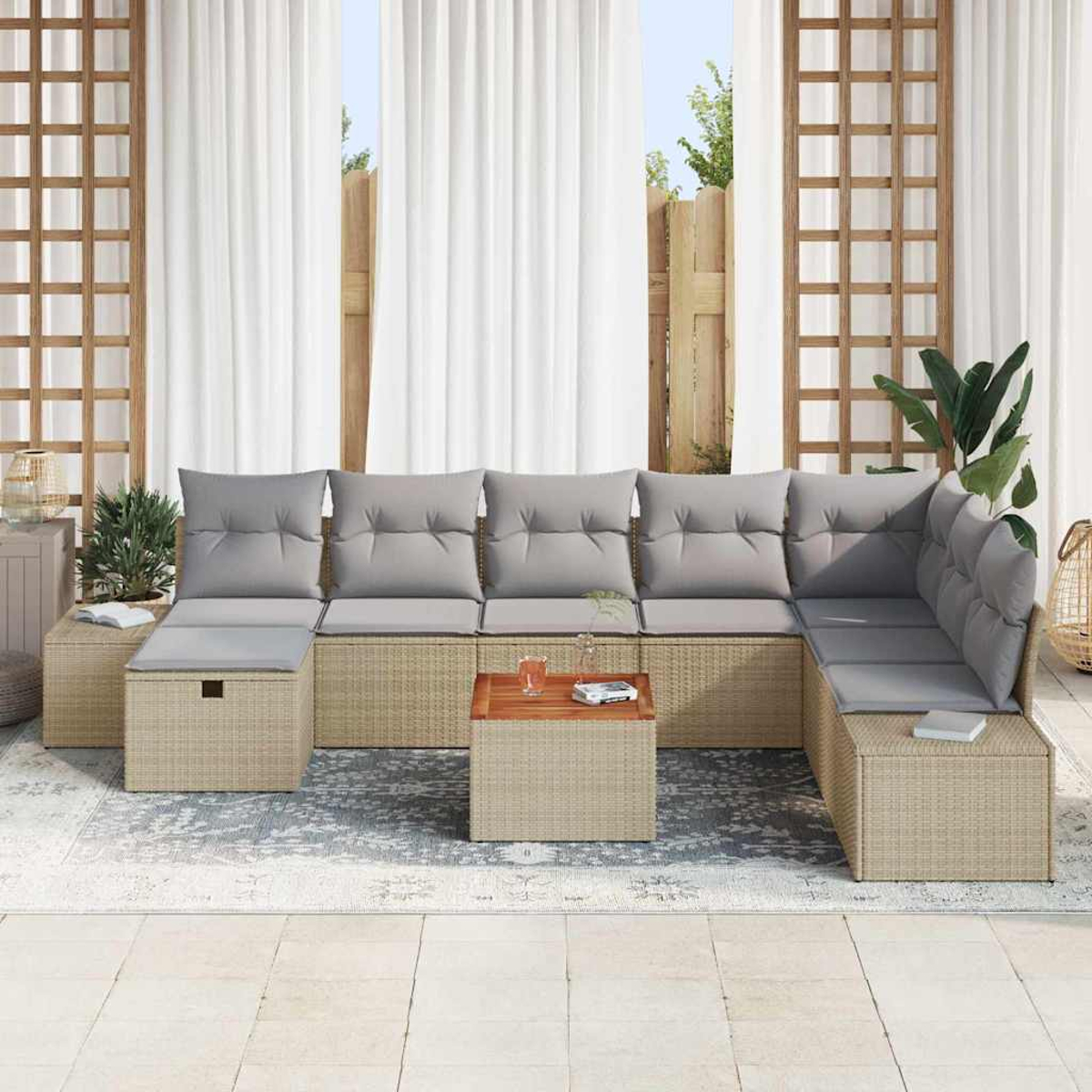 Beiges Outdoor-Ecksofa mit grauen Kissen. Kleiner Holztisch mit Getränk und Buch davor. Weiße Vorhänge dahinter.
