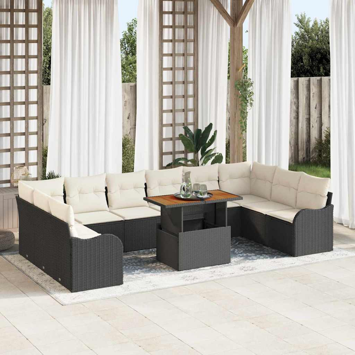 Terrassenset mit grauen Korbmöbeln und beigefarbenen Kissen. Ein Holztisch mit Glaskrug und Gläsern steht in der Mitte.