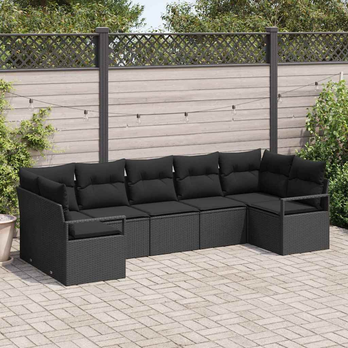 Un sofá seccional exterior de mimbre negro con cojines negros está sobre un patio de ladrillos. Una valla de madera al fondo.