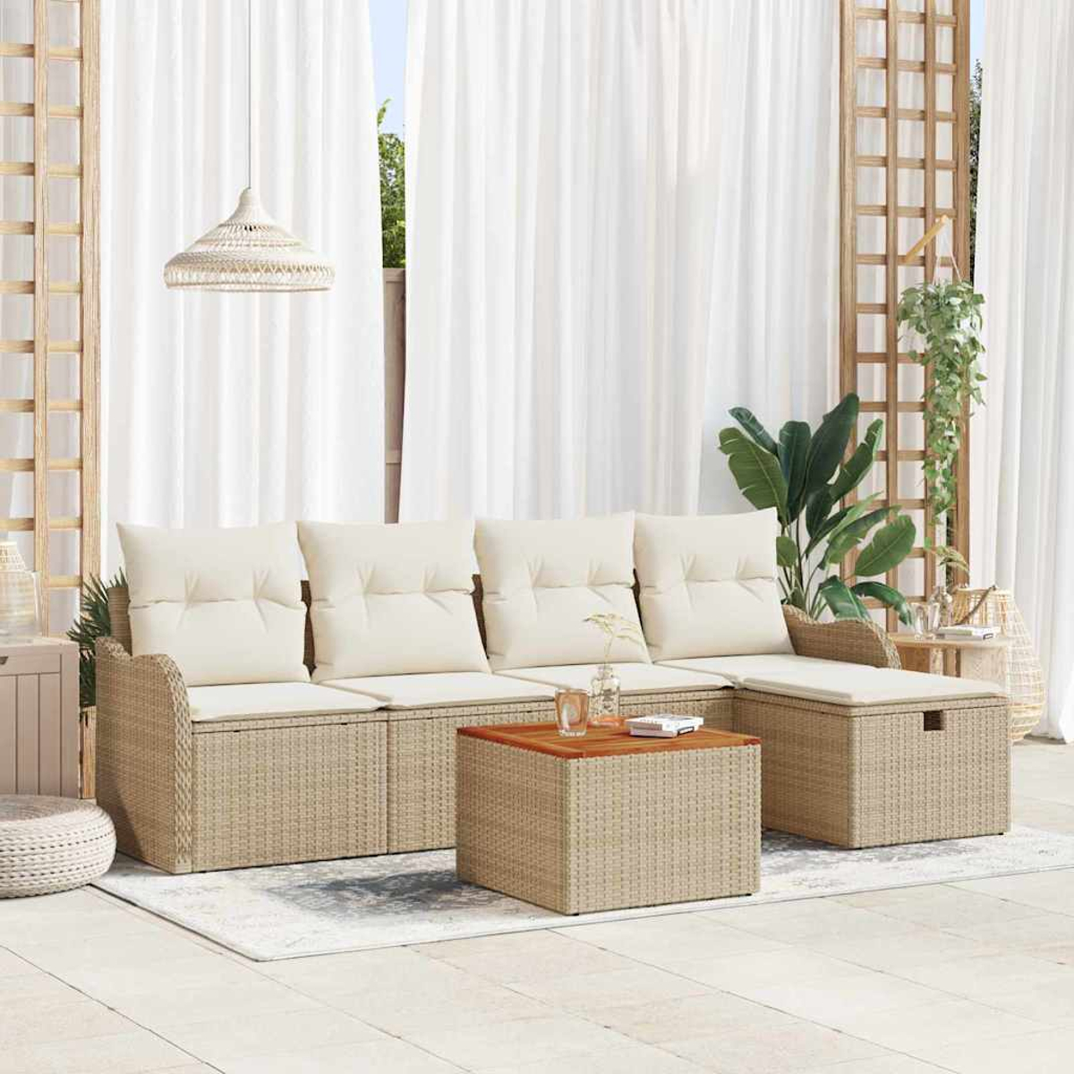 Outdoor-Sofa aus Korbgeflecht mit cremefarbenen Kissen, Holztisch, weißen Vorhängen und Hängepflanzen.