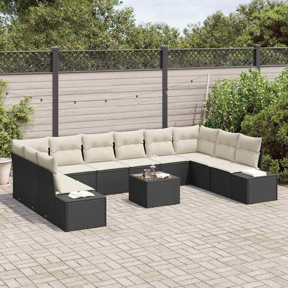 Outdoor-Ecksofa mit beigen Kissen auf einer gepflasterten Terrasse. Ein kleiner Tisch mit Gläsern steht in der Mitte. Dahinter ist ein Zaun.