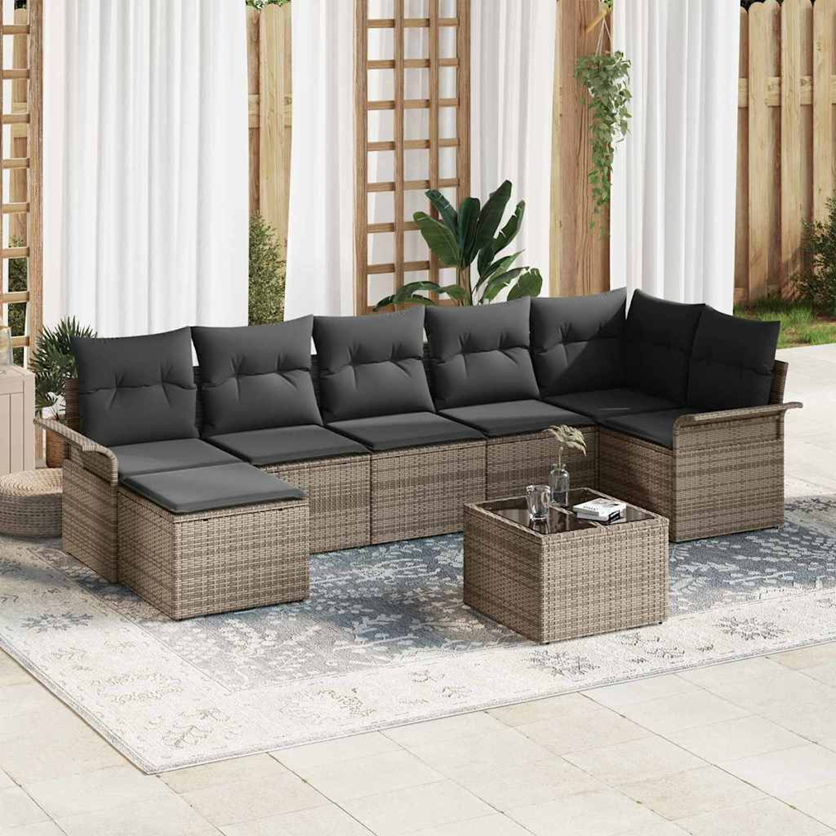 Outdoor-Ecksofa mit grauen Kissen, quadratischem Couchtisch und Teppich. Hintergrund mit Vorhängen, Holzgitter und Pflanzen.