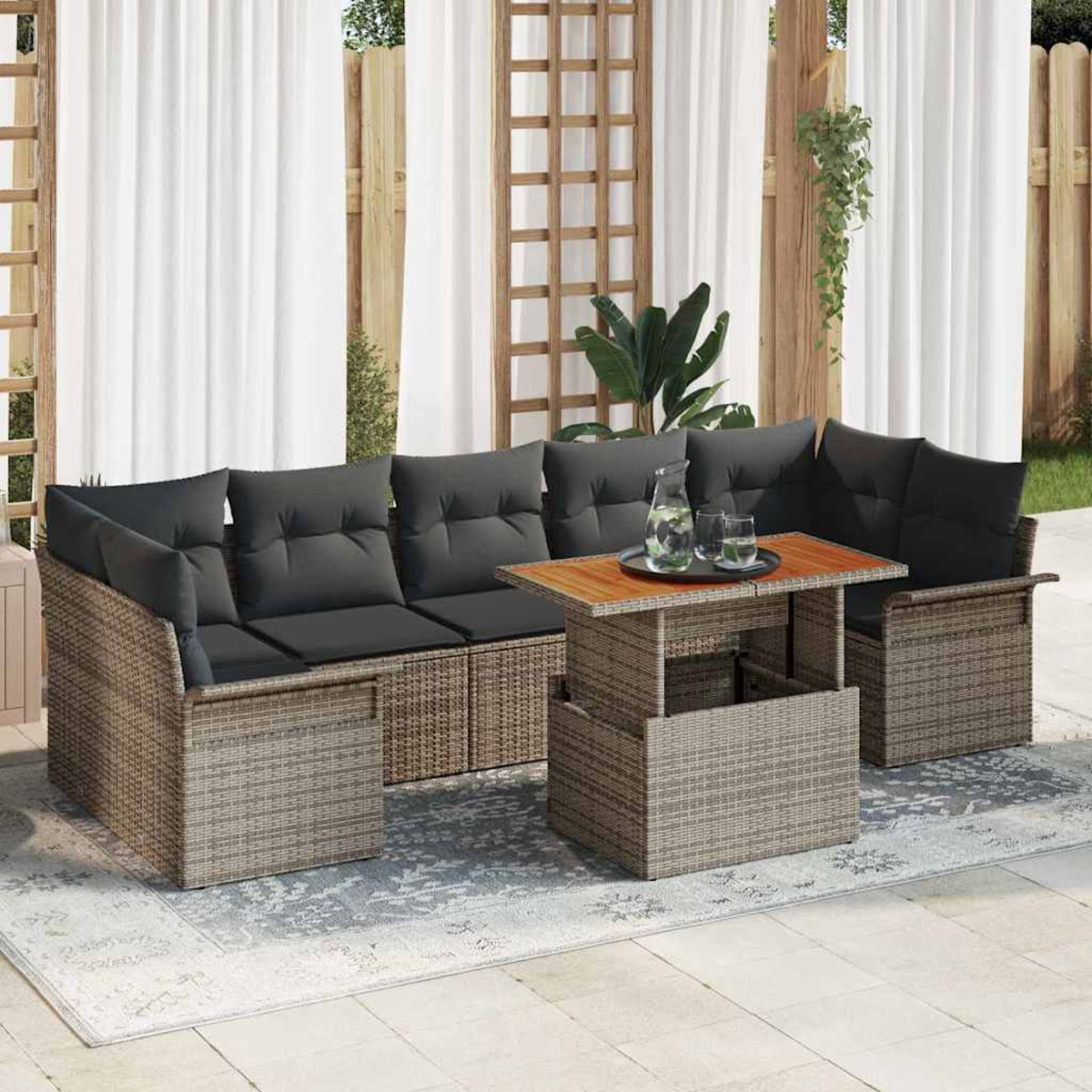 Ein Korbsessel-Set mit grauen Kissen und einem Holztisch. Weiße Vorhänge und Holzgitter bilden den Hintergrund.