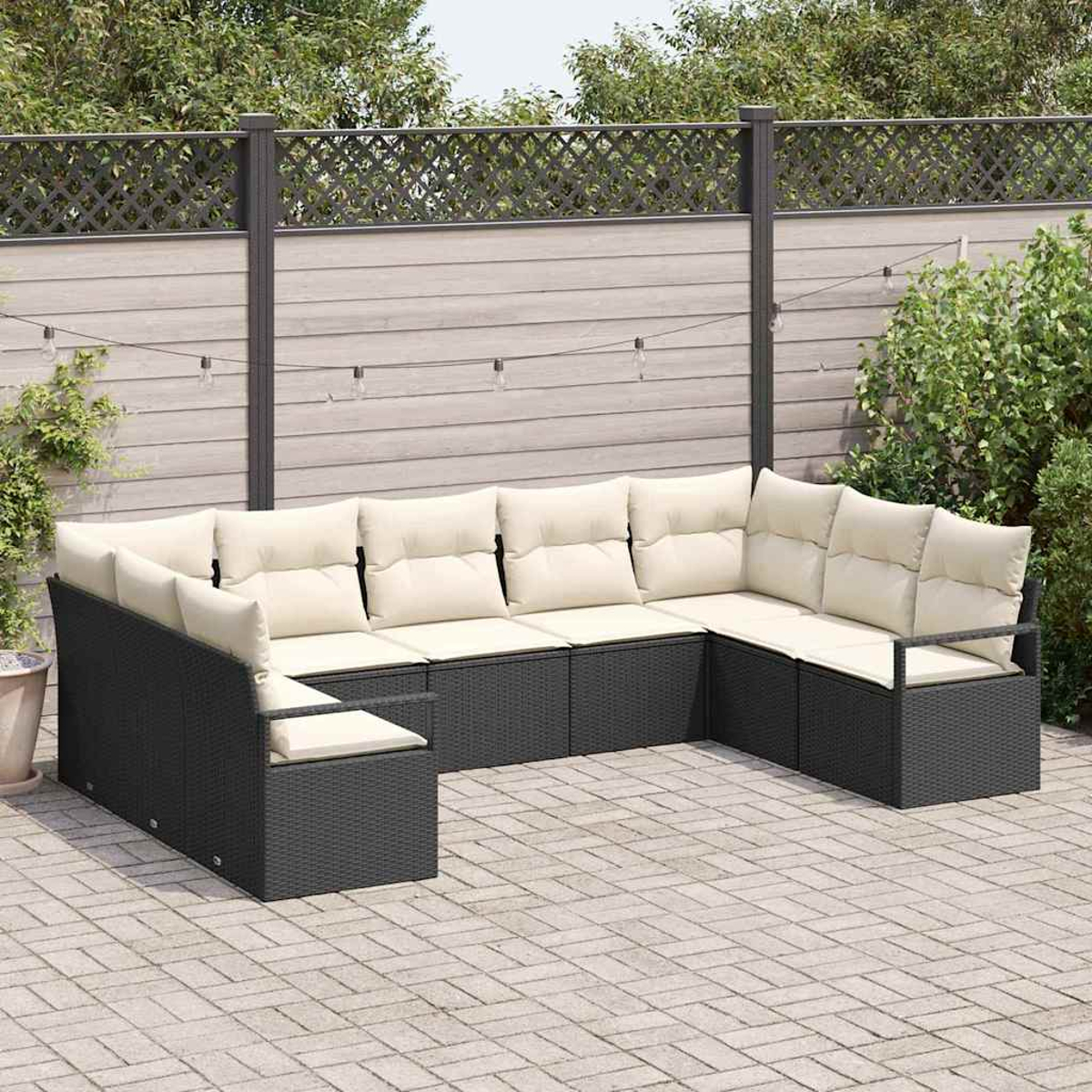 Ein großes, schwarzes Ecksofa aus Korbgeflecht mit cremefarbenen Kissen steht auf einer gepflasterten Terrasse. Ein Holzzaun und Grünzeug sind im Hintergrund.