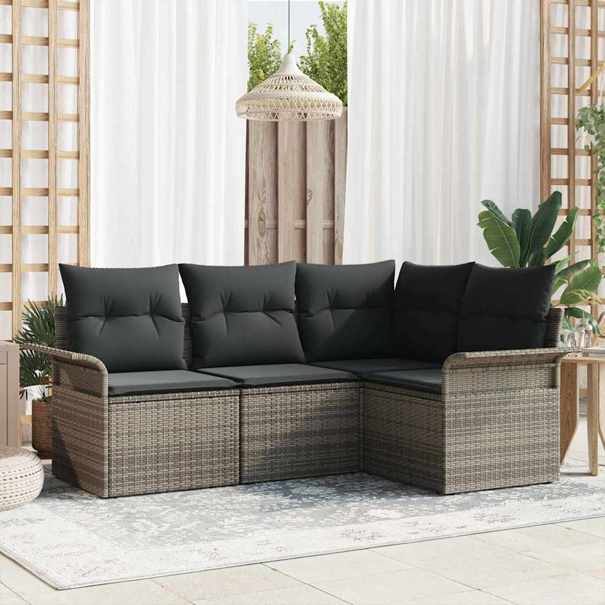 Outdoor-Ecksofa mit dunkelgrauen Kissen. Das Sofa ist aus grauem Rattan. Der Hintergrund hat weiße Vorhänge, eine Holzverkleidung und eine Hängelampe.