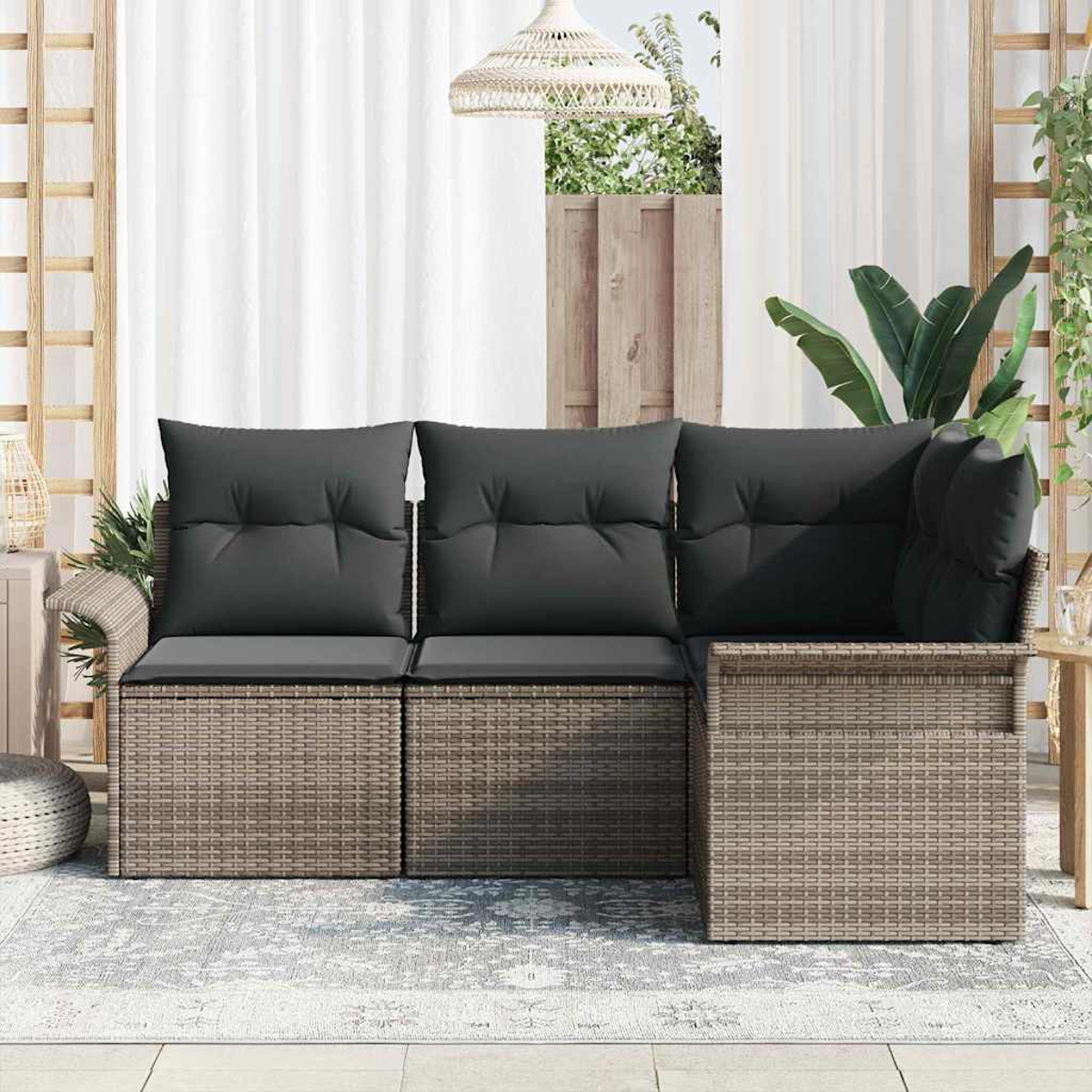 Ein Outdoor-Ecksofa mit grauen Kissen. Rahmen im Korbstil. Der Hintergrund umfasst Vorhänge, Pflanzen und ein Holzgitter.