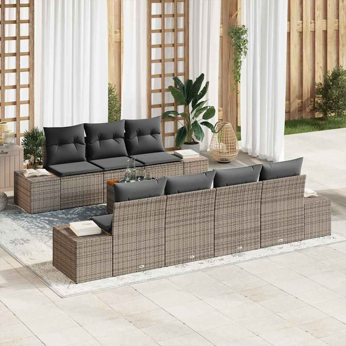 Szene im Freien mit Korbs Sofas, grauen Kissen, Pflanzen und weißen Vorhängen. Die Szene ist eine Außenterrasse mit einem Teppich.
