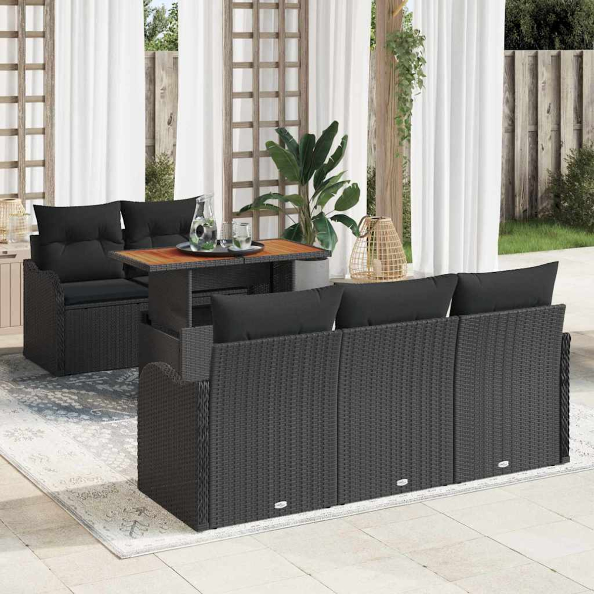 Gartenmöbel-Set für den Außenbereich. Enthält ein Sofa, Stühle und einen Tisch. Schwarzes Korbgeflecht mit schwarzen Kissen. Weiße Vorhänge und Grün im Hintergrund.