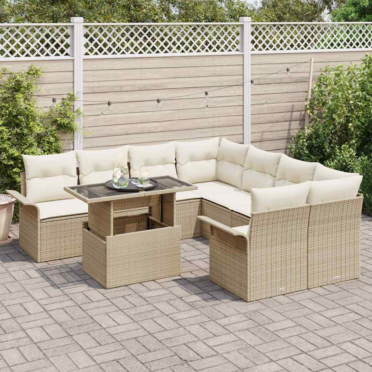 Ein beiges Outdoor-Ecksofa aus Korbgeflecht mit cremefarbenen Kissen und einem Tisch. Ein weißer Zaun und Grünzeug im Hintergrund.