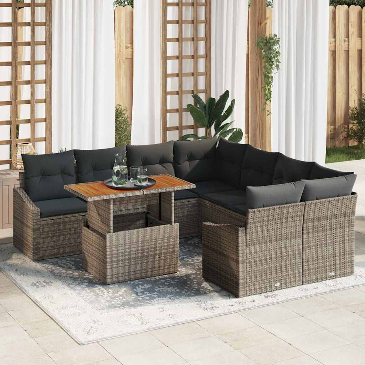 Gartenmöbel mit grauen Kissen, Holztisch und Teppich. Weiße Vorhänge und Holzzaun im Hintergrund.