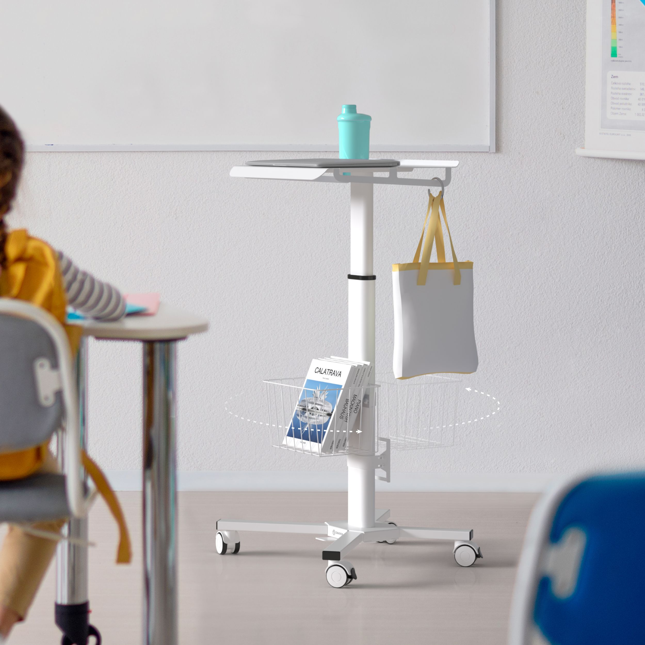 Ein weißer mobiler Schreibtisch mit Laptop, Wasserflasche, Büchern und einer Tragetasche, in der Nähe eines Schülers.