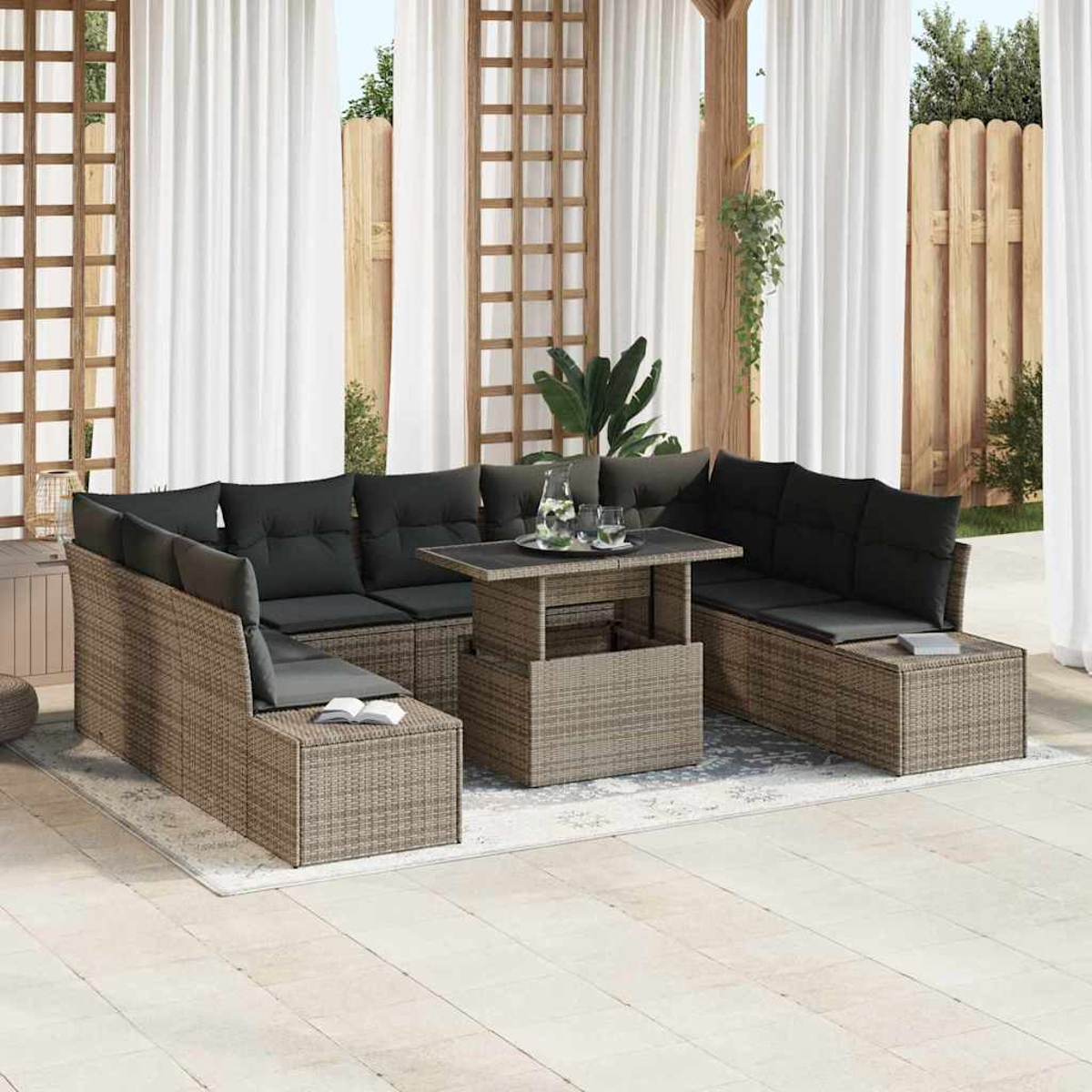 Outdoor-Ecksofa mit dunklen Kissen um einen Tisch, auf einem Teppich. Weiße Vorhänge und Holzzaun im Hintergrund.