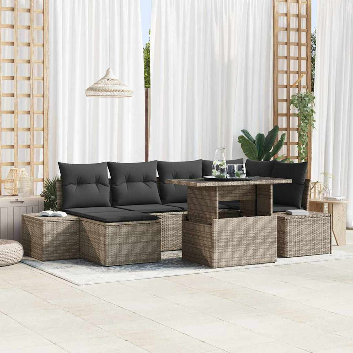 Garten-Sitzgruppe mit grauen Kissen, Tisch und weißen Vorhängen im Hintergrund. Braune Webmöbel und ein weißer Teppich.