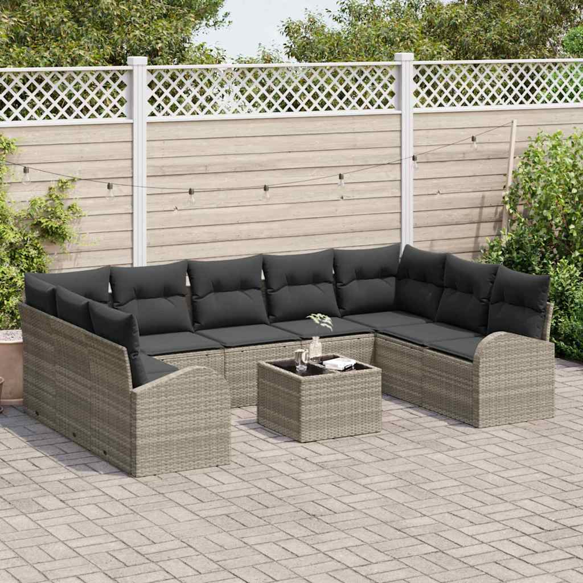 Graues Korbsessel mit schwarzen Kissen und einem passenden Couchtisch in einem Garten.