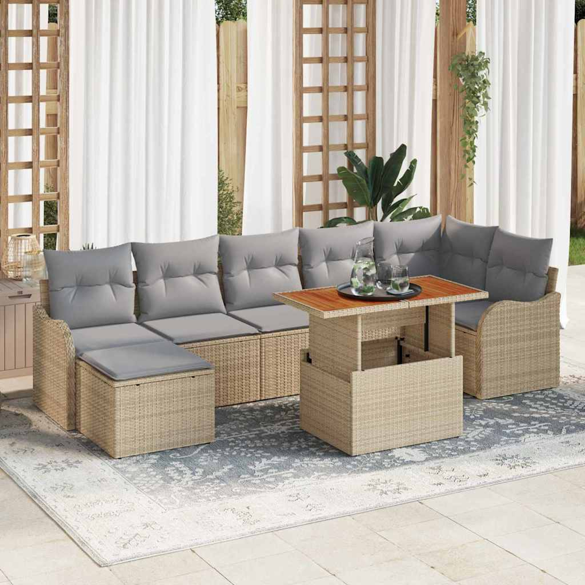 Gartenmöbel-Set aus Korbgeflecht mit grauen Kissen, einem Holztisch und einem gemusterten Teppich. Weiße Vorhänge und ein Holzgitter im Hintergrund.