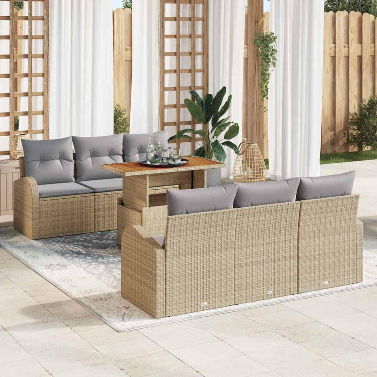Gartenmöbel-Set aus Rattan mit grauen Kissen und Holztisch. Beinhaltet Sofa, Stühle und Tisch auf einem gemusterten Teppich.