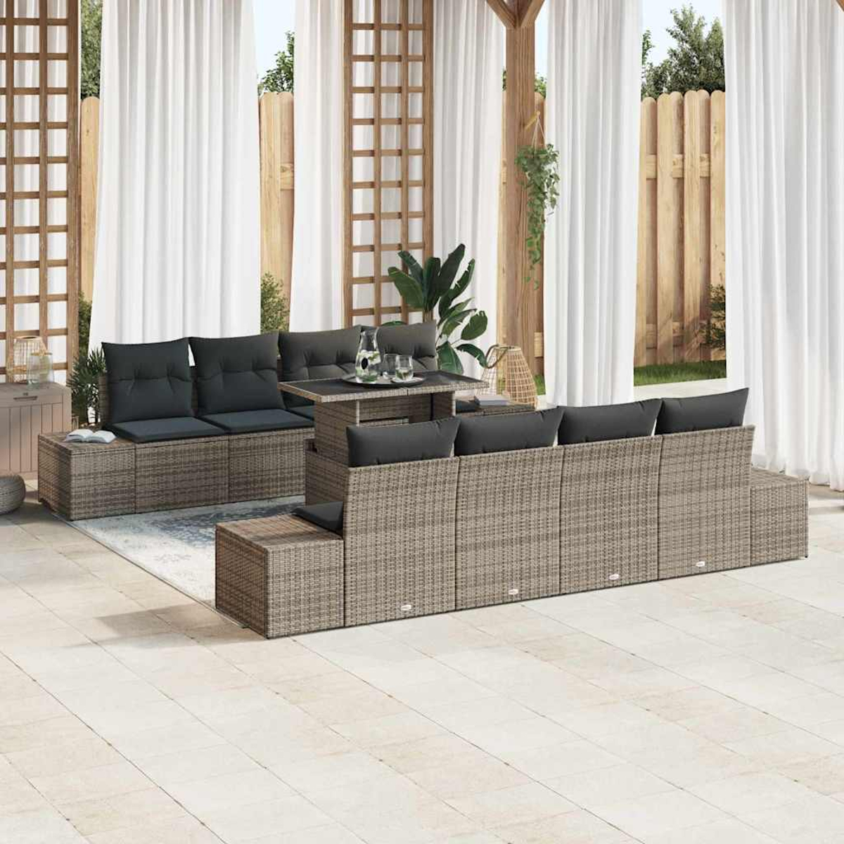Gartenmöbel-Set mit grauen Kissen. Beinhaltet einen Tisch und modulare Sitzgelegenheiten. Hintergrund mit Vorhängen und Holzzaun.