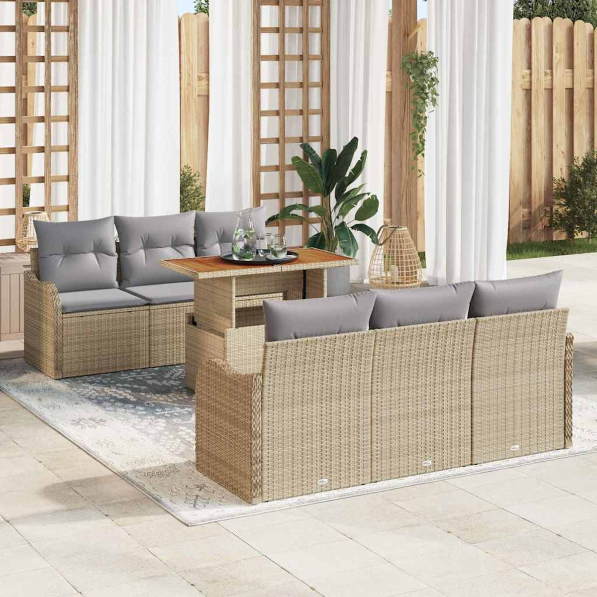 Ein Rattanset mit grauen Kissen. Enthält ein Sofa, eine Doppelliege und einen Couchtisch auf einem Teppich. Transparente Vorhänge im Hintergrund.