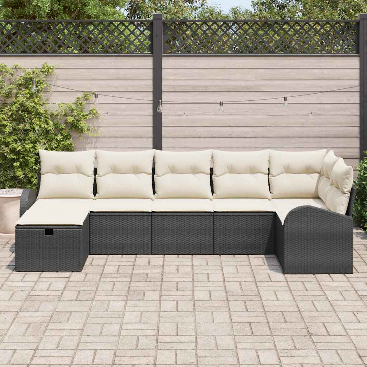 Outdoor-Ecksofa mit cremefarbenen Kissen und dunkelgrauem Rattansockel. Dahinter ein Holzzaun und grüne Pflanzen. Der Boden ist aus Backstein.