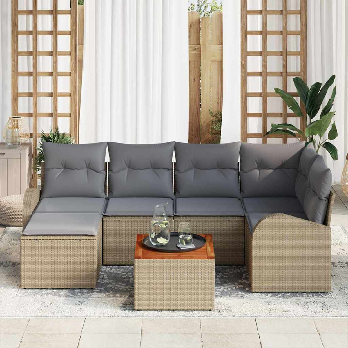 Outdoor-Rattan-Ecksofa mit grauen Kissen, einem Holztisch mit Getränken und einer grünen Pflanze. Weiße Vorhänge und Holzgitter im Hintergrund.