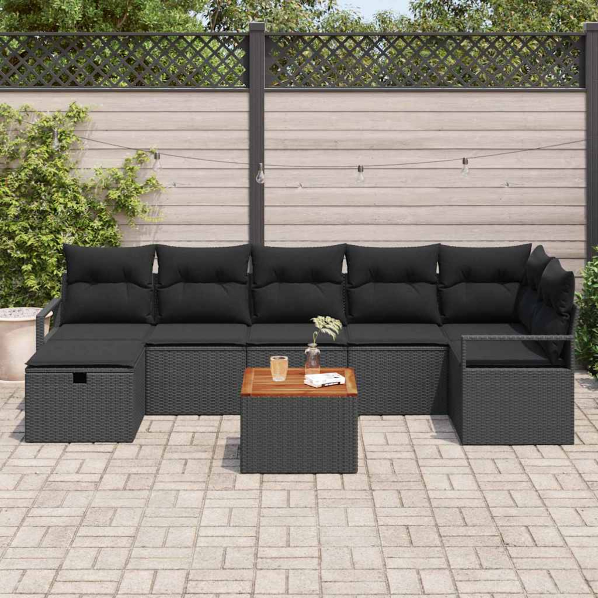 Gartensofa mit schwarzen Kissen, kleinem Tisch und Ziegelpflaster. Holzzaun mit Lichterkette im Hintergrund.