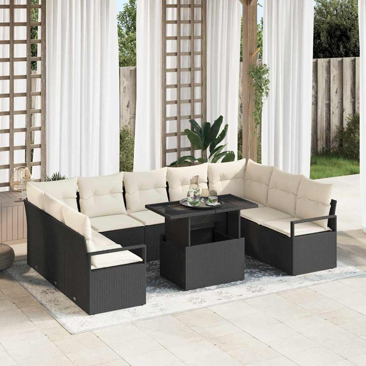 Garten-Terrassenset mit schwarzen Korbmöbeln, beigen Kissen, einem schwarzen Tisch mit Getränken und weißen Vorhängen. Hintergrund mit Grün.