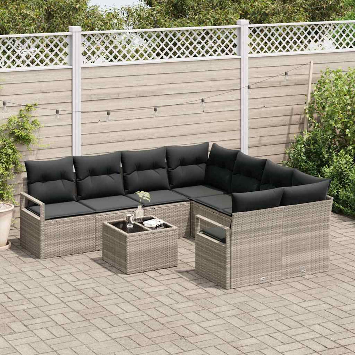 Outdoor-Ecksofa mit schwarzen Kissen auf einer Ziegelterrasse. Davor steht ein kleiner Tisch. Im Hintergrund ein weißer Zaun und Grün.