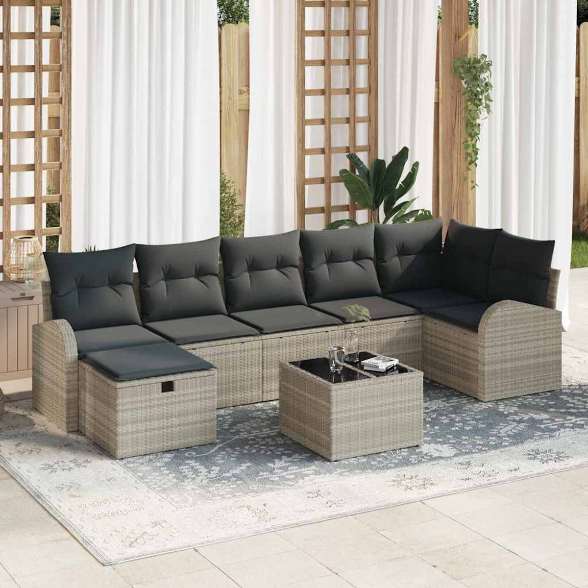 Outdoor-Ecksofa mit grauen Kissen. Davor steht ein kleiner quadratischer Tisch. Weiße Vorhänge und Holzgitter im Hintergrund.