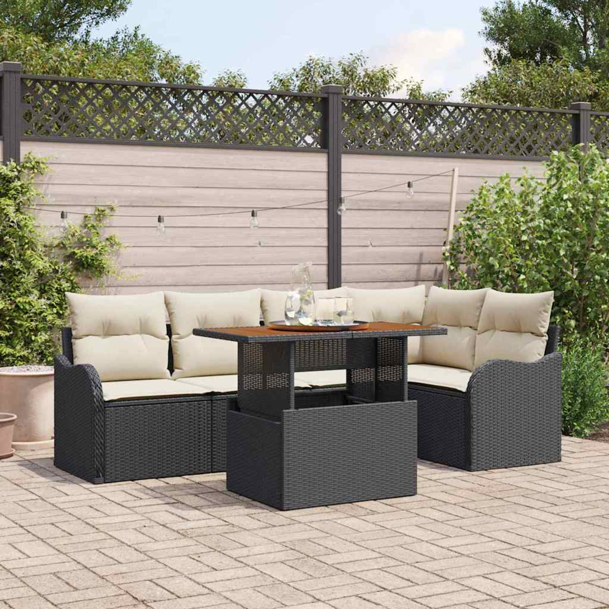 Sitzbereich im Freien mit einem dunklen Korbmöbelsofa, beigen Kissen und einem braunen Tisch auf einer Ziegelterrasse.
