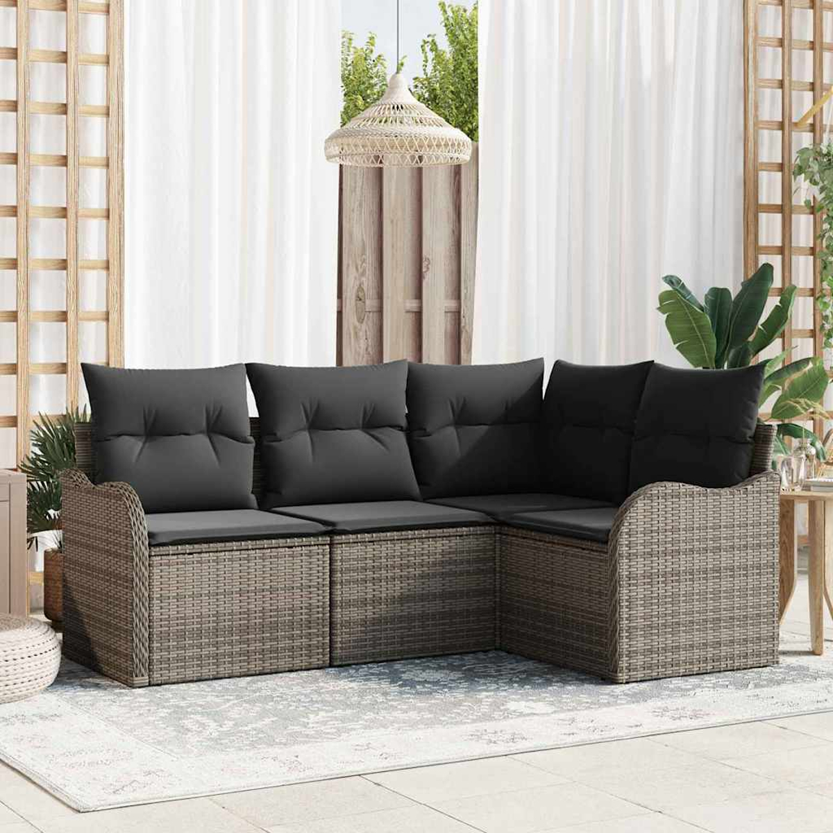 Ein Ecksofa im Freien mit grauen Kissen steht auf einer Terrasse. Vor dem Sofa liegt ein weißer Teppich, im Hintergrund weiße Vorhänge.