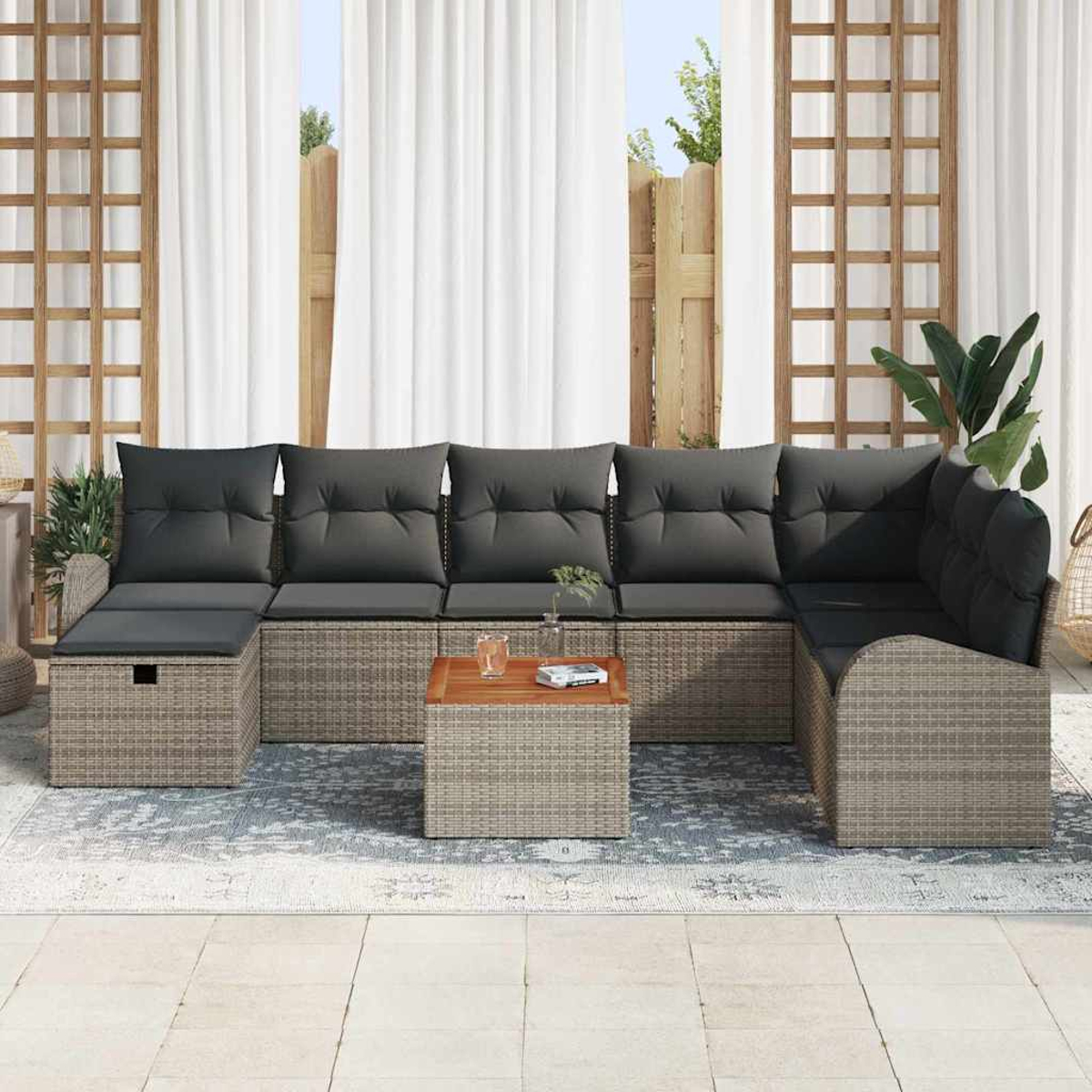 Outdoor-Ecksofa mit grauen Kissen, einem hölzernen Couchtisch und einem Teppich. Weiße Vorhänge und ein Holzgitter im Hintergrund.