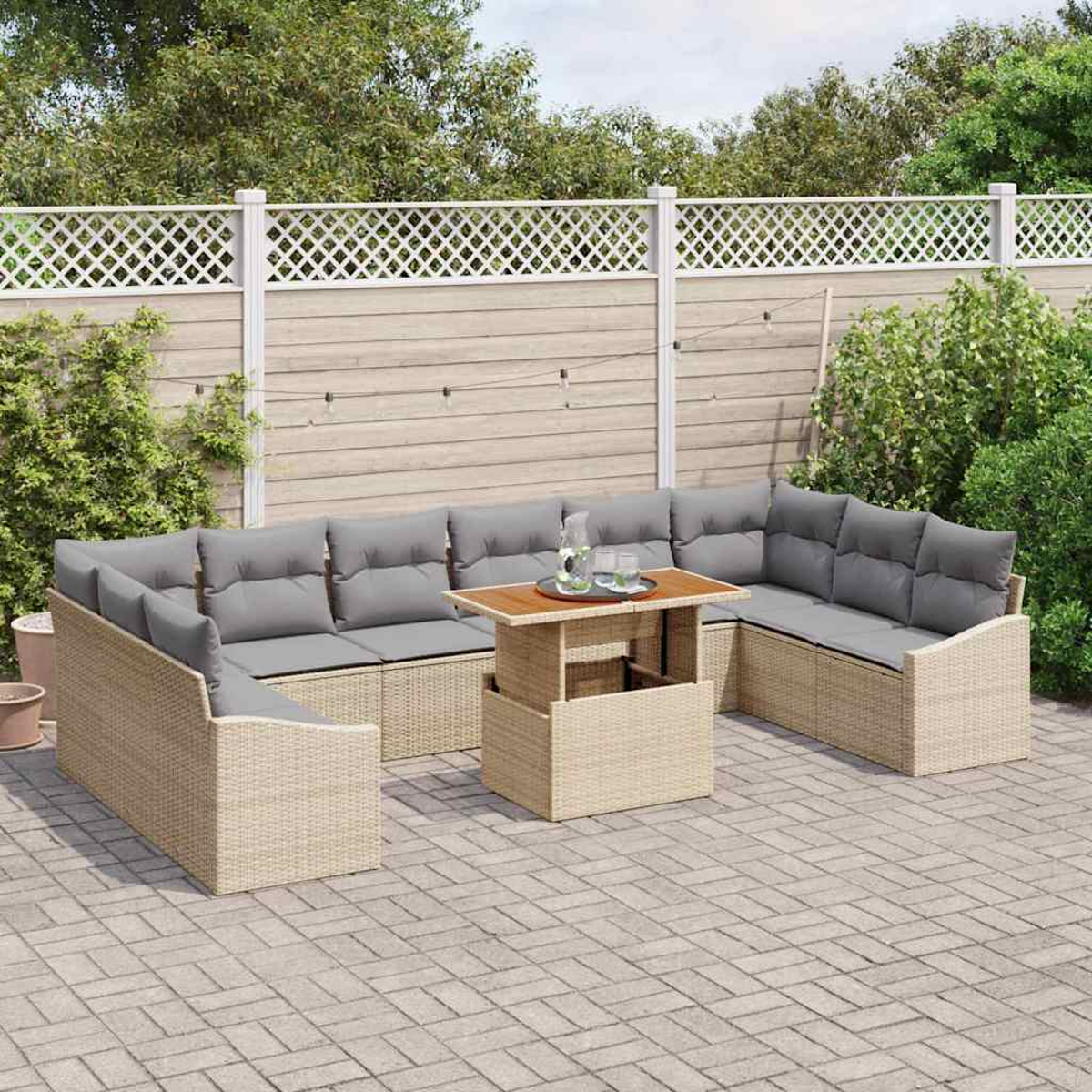 Garten-Terrassenset mit beigen Korbmöbeln, grauen Kissen und einem Holztisch. Vor einem weißen Zaun und Grün.
